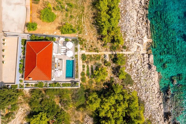 Aerial view of Luxury villa Blue Planet with pool at the seafront on the island of Korcula
