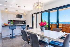 Living room with fully equipped kitchen with kitchen island in luxury villa Blue Planet
