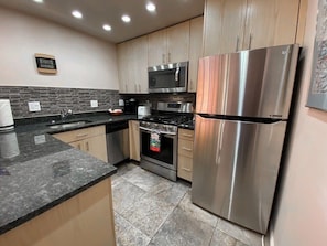 Fully-equipped kitchen with modern stainless steel appliances and a breakfast bar