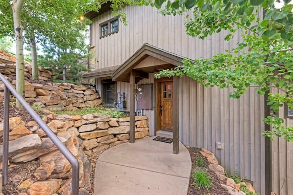 An inviting exterior, nestled among aspen and pine trees, welcomes you into this beautiful and charming apartment.