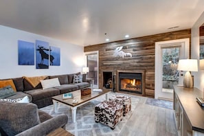 Relax in the family room with a plush sectional sofa, a warm indoor wood fireplace, and a large flat-screen TV