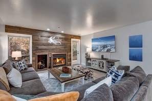 Relax in the family room with a plush sectional sofa, a warm indoor wood fireplace, and a large flat-screen TV