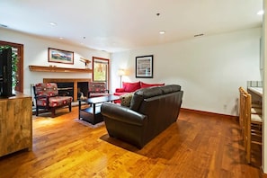 Relax in the family room with a leather sofa, a plush sofa, armchair seating, an indoor wood fireplace, and a flat-screen TV