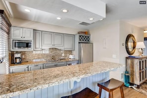 The light-filled kitchen features stainless steel appliances, sophisticated finishes and a convenient bar area for serving and dining. With the home’s open layout, the chef in your group won’t have to miss out on the fun.