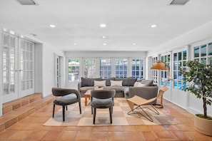 Indoor outdoor living with glass French doors leading to backyard.