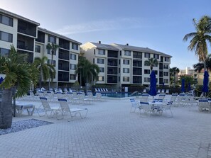 Large pool with lots of tables, umbrellas and chairs