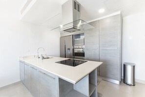 Kitchen with refrigerator, RO system, dishwasher, microwave, cooktop and oven.