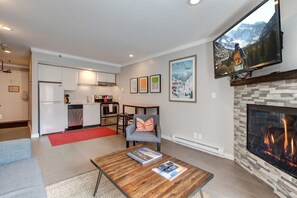 Another view from the gorgeous living area highlights the efficient layout and bright decor of this fabulous studio space. A small, but mighty kitchen area is fully equipped while a cozy dining area seats two.