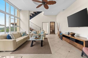 The living space is bright and airy, with a 70" Smart TV and great sightlines to the pool area.  