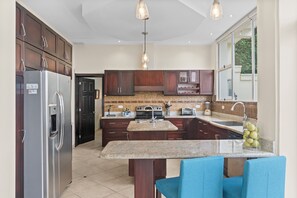 The large kitchen is well-equipped and features and island and breakfast bar.