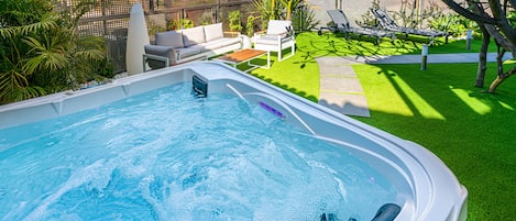 Jacuzzi climatisé et d'usage privée avec salon de jardin et transats