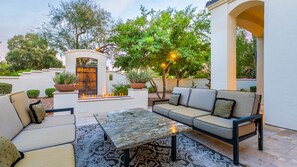 Front porch fenced & gated patio w/ comfy couches & fire feature 