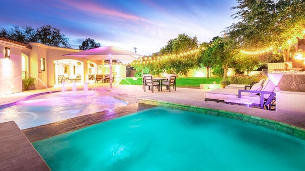 Elevated spa connected to the pool w/ water features, lights, & pool loungers