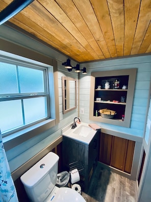 Bathroom Includes a Walk In Shower, Toilet, Sink and plenty of Towels 