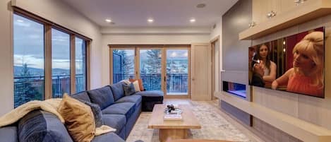 Spacious living room with fireplace, 65" TV, mountain views