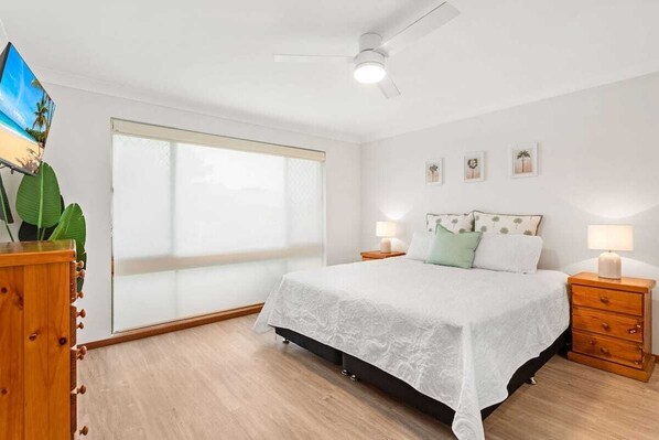 Main bedroom with King size bed, TV & ceiling fan and wardrobe.