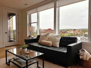 Modern lounge space with natural light and balcony access.