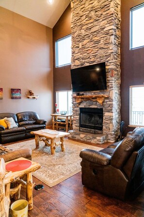 Main level gathering area with fireplace and TV