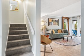 Stairs up to second floor and living room with patio access.