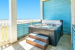 Relax in the hot tub overlooking the beach