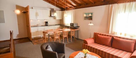 Ferienwohnung für max. 6 Personen "Schauinsland"-Wohnraum mit großzügiger Küchenzeile, Esstisch, Sessel und Sofa