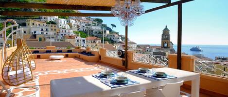 large terrace with table, chairs banches, sea view and attached to the kitchen