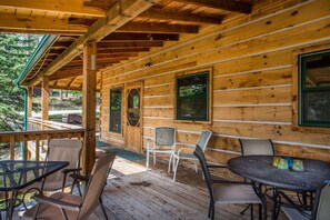 Main level deck, just off of the kitchen with a table and chairs and a gas BBQ grill