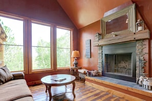 Main floor living room area with wood fireplace and large windows with great views