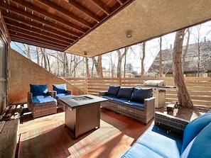 Fenced patio with comfortable seating, propane fire table and propane grill
