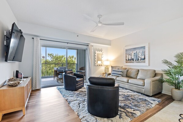 Living area offers plenty of seating, smart TV, and sliders to the balcony.