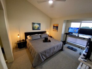 Spacious MBR with king bed and nook set up with double-monitors/stand-up desk.