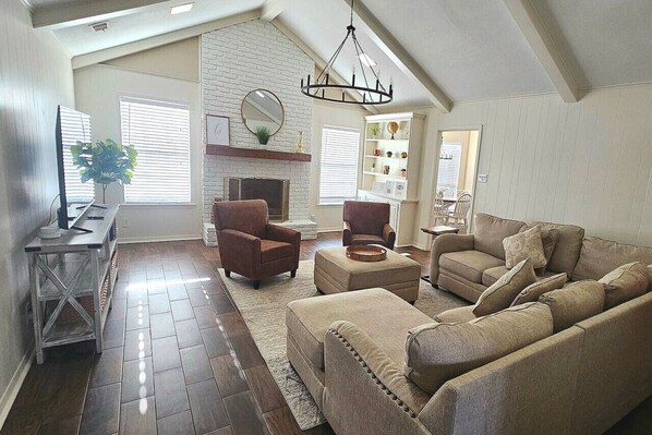 Large open living areas with deep seating for gathering and watching TV in the large screen .