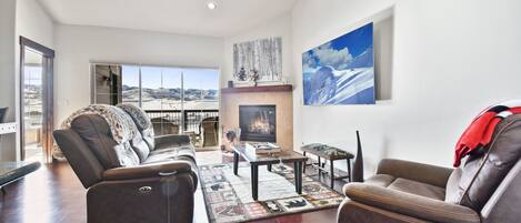 Living room with large HDTV and fireplace, overlooking the Park City mountain range.