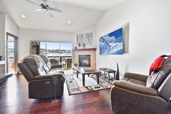 Living room with large HDTV and fireplace, overlooking the Park City mountain range.