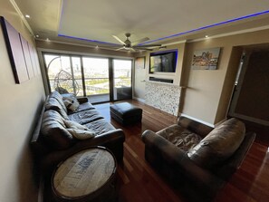 Pottery Barn leather couches, bourbon barrel tables, Samsung QLED smart tv 