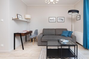 A tastefully designed living room with a sleek TV unit, bright yellow armchair, and comfortable seating. A modern entertainment space.
