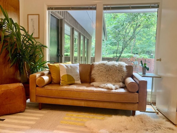 The breakfast nook, right off the kitchen, features a 2-3 person leather sofa and looks into the internal courtyard central to the home. Live plants, soft rugs and throws, and hand selected art!