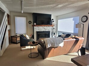 The cozy living area has a fireplace and television.