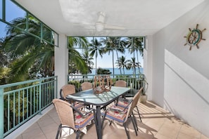 Private balcony with dining table, ceiling fan and beautiful pool and beach views