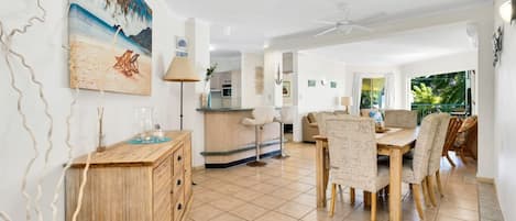 Dining area and lounge opening into private balcony with beach view