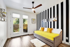 A perfect simplistic room featuring a trundle bed (two twins) and a walk-out patio with two lounge chairs to sip coffee in the morning.