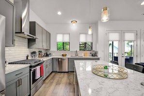 Modern kitchen with spacious marble-topped island, perfect for gourmet cooking and entertaining.