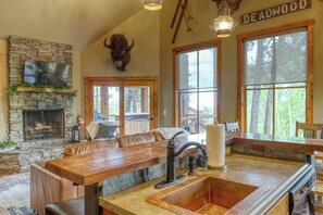 Main level living room with wood-burning fireplace and large windows