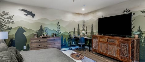 Primary Bedroom with King size bed, accent wall, and hand painted mural. 