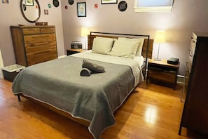 Master bedroom with queen bed, dresser, night stand