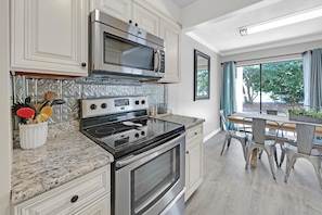 Full kitchen with floor to ceiling glass patio doors and golf course view.