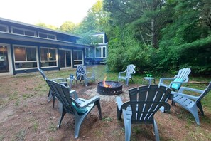 The back of the home offers a rustic retreat , surrounded by trees, for a camp fire. Wood can be  purchased locally.