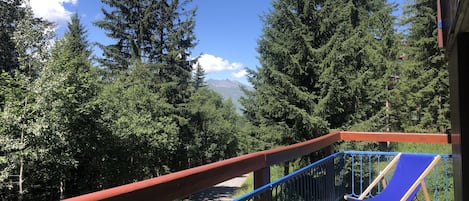 Terrasse au calme accueillant l'été 4 transats, ainsi qu'une table et 4 chaises