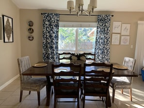 Spacious dining room with long table for family meals. Blackout curtains.