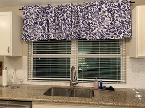 Kitchen winder overlooks backyard patio. Blinds can be closed for privacy.